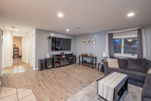 living room with light hardwood / wood-style floors and a textured ceiling