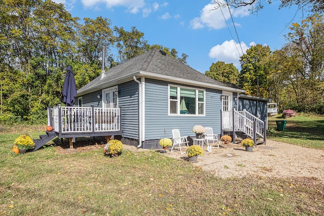 view of property exterior with a lawn and a deck