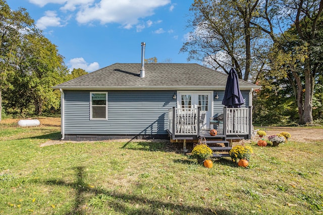 rear view of property featuring a wooden deck and a lawn