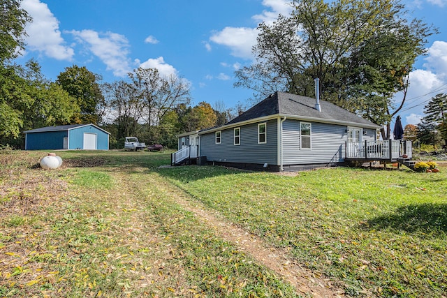 view of side of property featuring a yard, an outbuilding, and a deck