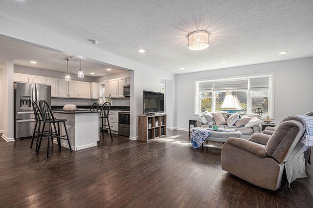 living room featuring dark hardwood / wood-style floors and a textured ceiling