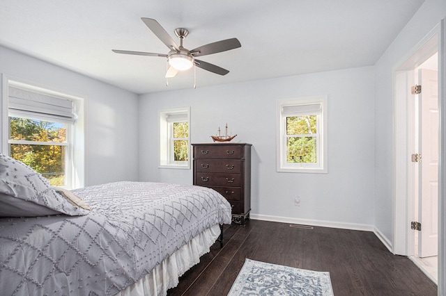 bedroom with multiple windows, ceiling fan, and dark hardwood / wood-style floors