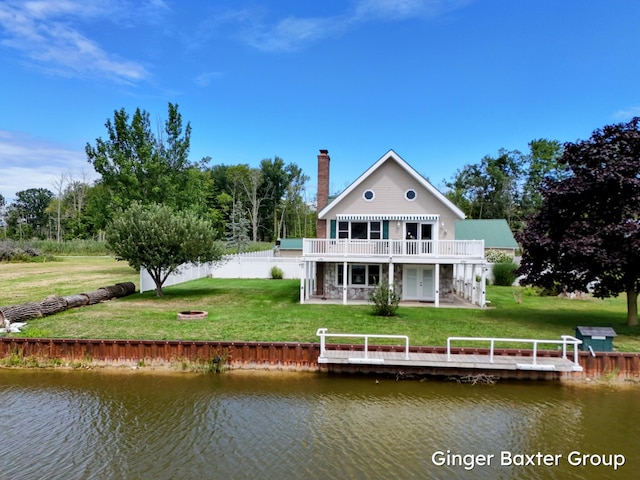 rear view of property featuring a yard and a deck with water view