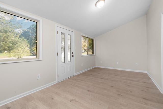 foyer entrance with lofted ceiling and light hardwood / wood-style flooring