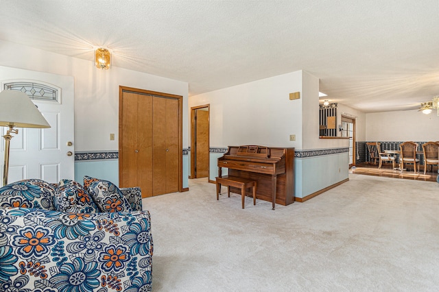 living room with carpet floors, a textured ceiling, and ceiling fan