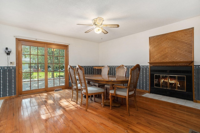 dining space featuring ceiling fan, a textured ceiling, and light hardwood / wood-style flooring