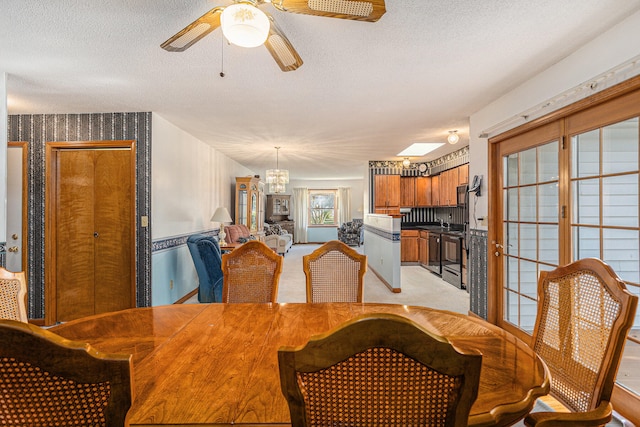 dining room with light carpet, a textured ceiling, and ceiling fan with notable chandelier