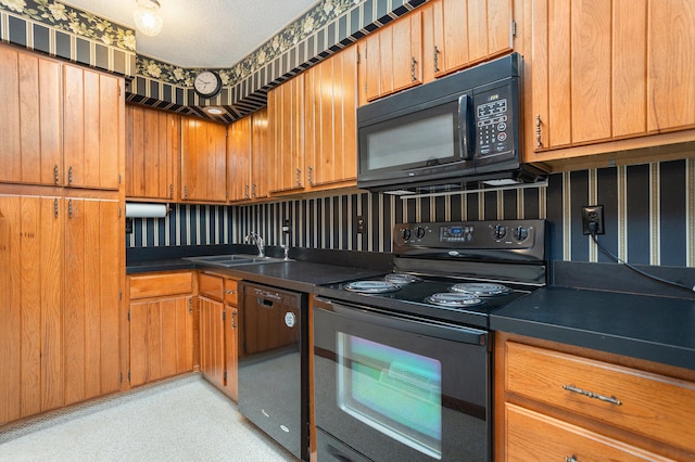 kitchen featuring a textured ceiling, black appliances, and sink