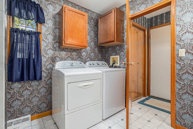 laundry room with independent washer and dryer and cabinets