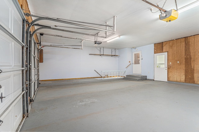 garage with a garage door opener and wooden walls