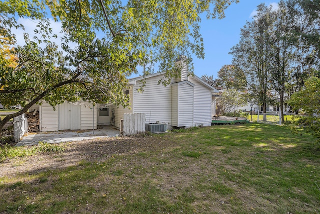 rear view of property with a yard and cooling unit