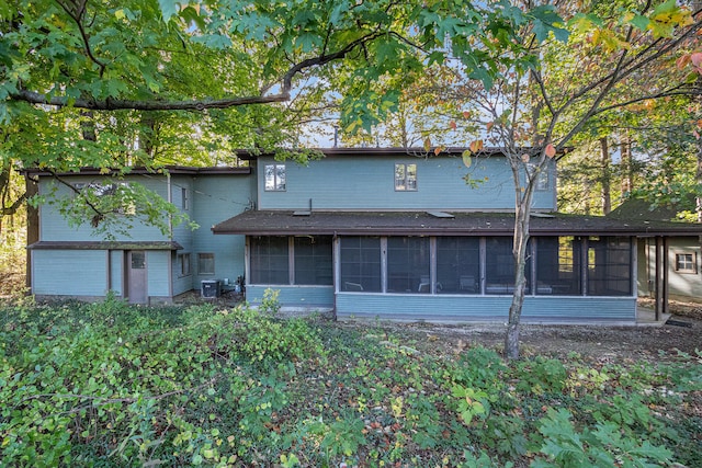 rear view of property with cooling unit and a sunroom