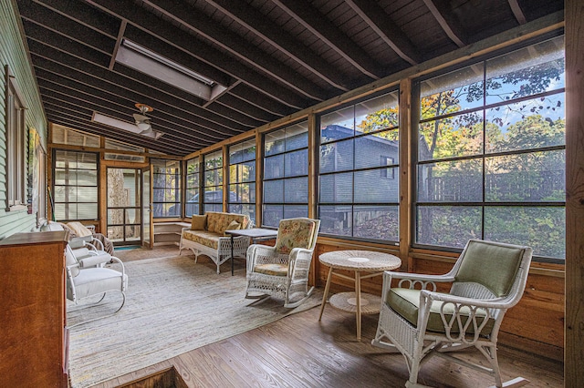 sunroom featuring plenty of natural light, wooden ceiling, and vaulted ceiling with beams