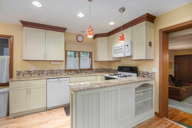 kitchen with hanging light fixtures, kitchen peninsula, white appliances, and light hardwood / wood-style floors