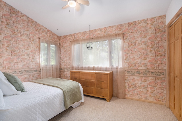 bedroom featuring light carpet, vaulted ceiling, and ceiling fan