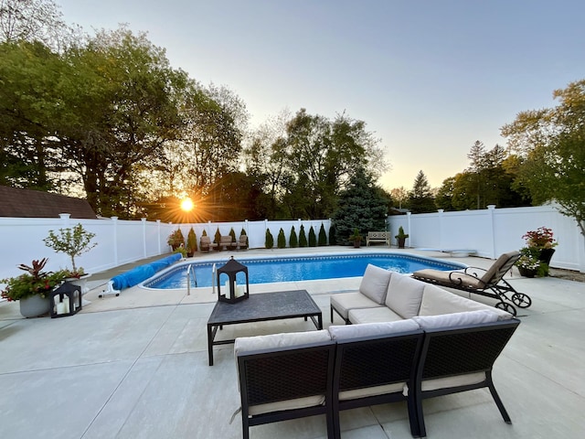 pool at dusk with a patio area