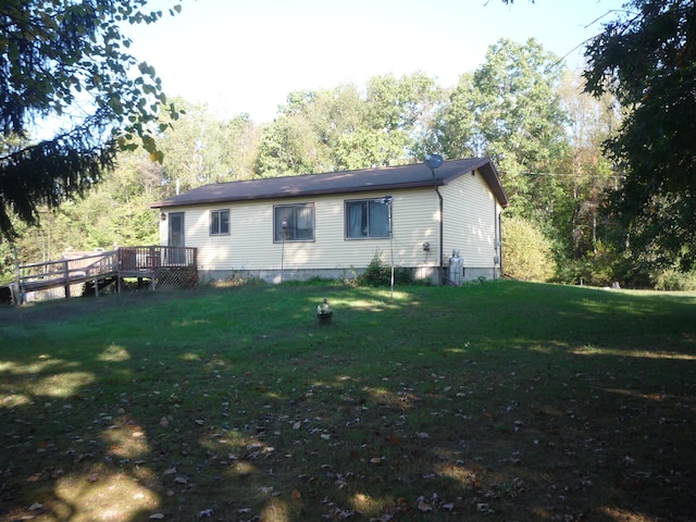 rear view of property with a deck and a yard