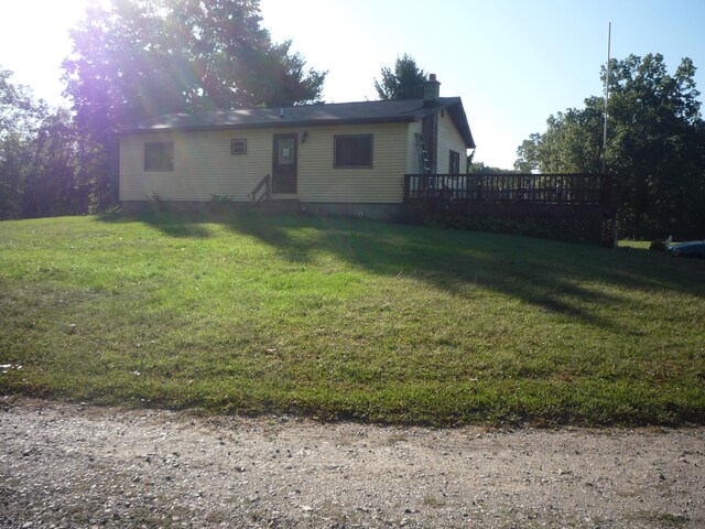 view of front of house featuring a wooden deck and a front lawn