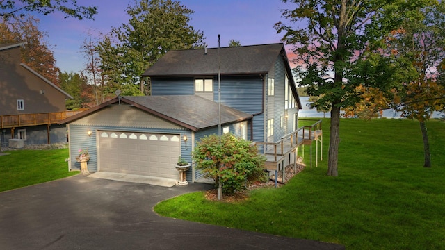 view of front of home featuring a garage and a yard