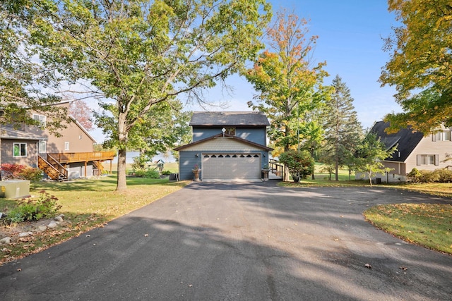 view of front of property with a garage, a front yard, and an outbuilding