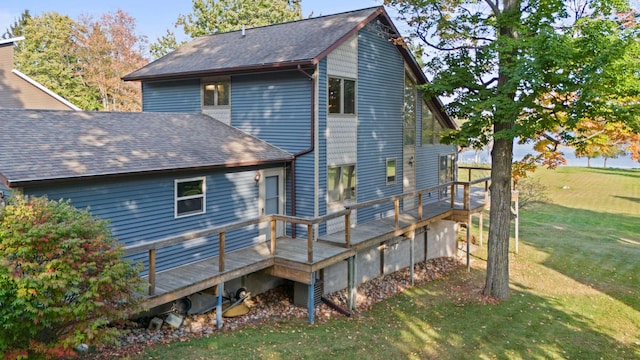 rear view of house with a deck and a yard