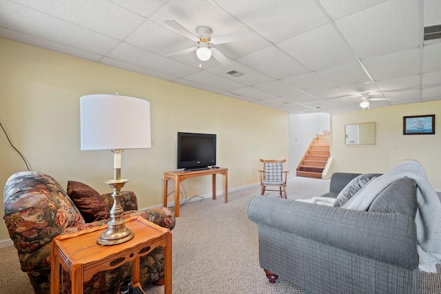 living room with a drop ceiling, ceiling fan, and carpet flooring