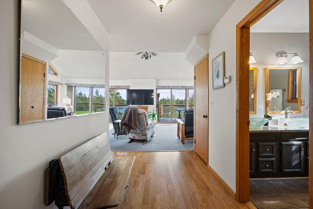 corridor with hardwood / wood-style floors, sink, and a wealth of natural light