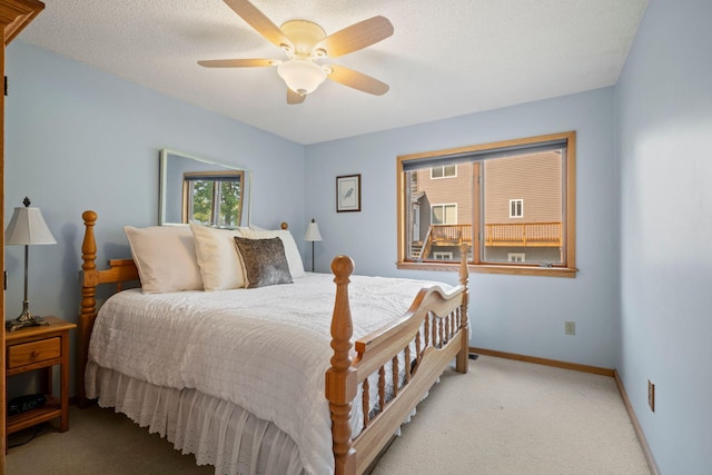 carpeted bedroom with ceiling fan and a textured ceiling