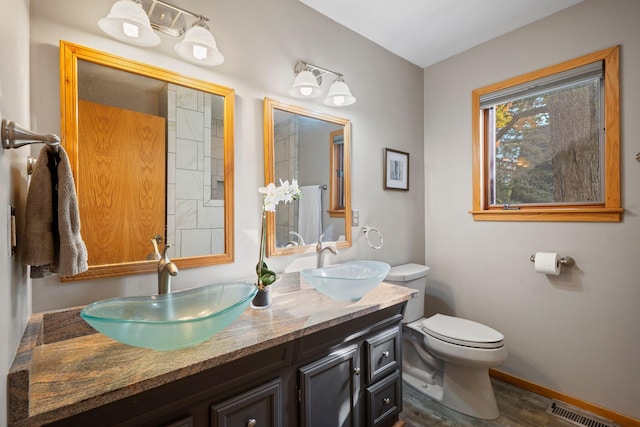 bathroom with wood-type flooring, vanity, and toilet