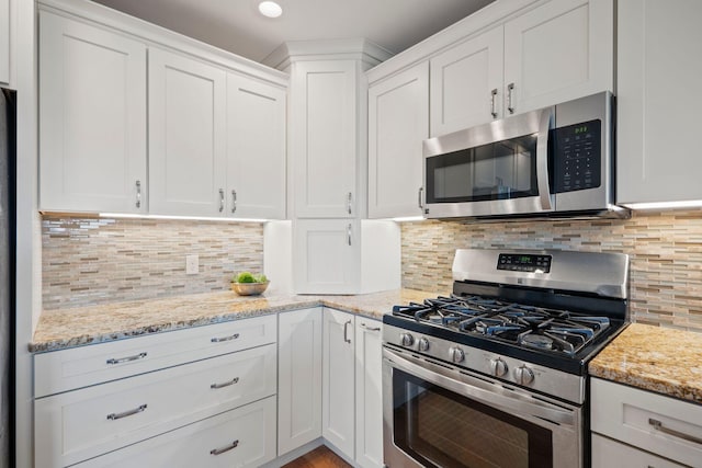 kitchen with white cabinetry, stainless steel appliances, and tasteful backsplash