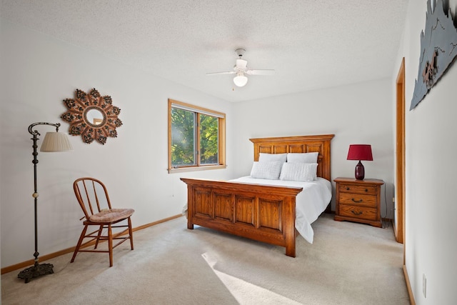 bedroom featuring light carpet, ceiling fan, and a textured ceiling