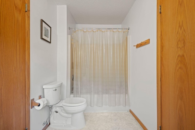 bathroom featuring shower / bathtub combination with curtain, a textured ceiling, and toilet