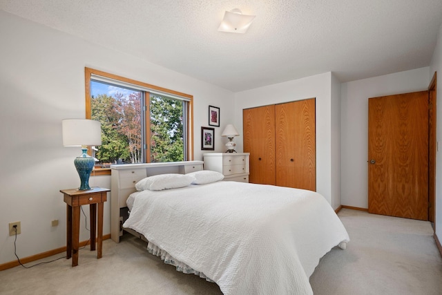 bedroom with light carpet, a textured ceiling, and a closet