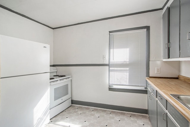 kitchen with gray cabinets, ornamental molding, sink, and white appliances