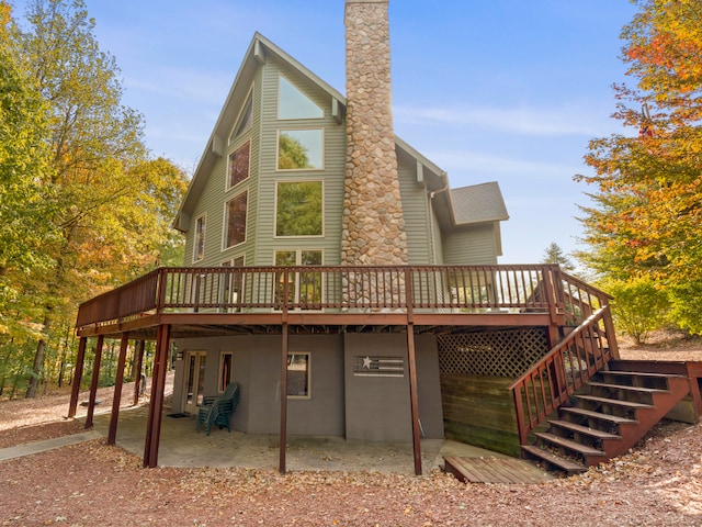 back of property with a deck and a patio