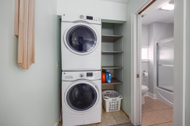 clothes washing area with stacked washing maching and dryer and light tile patterned floors