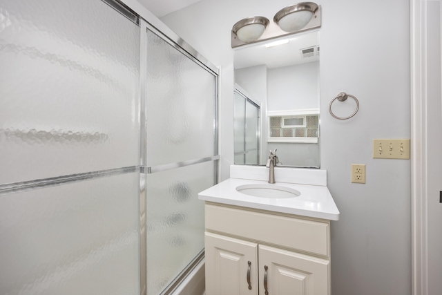 bathroom with vanity and a shower with door