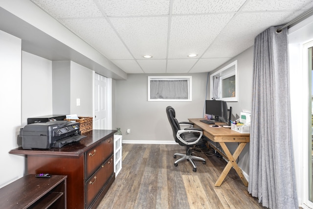 home office featuring wood-type flooring and a paneled ceiling