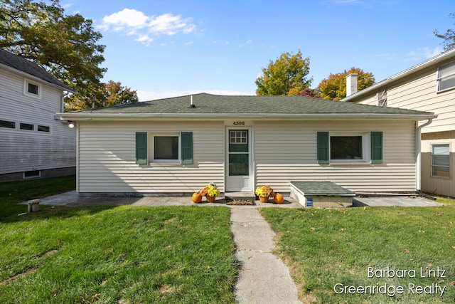 back of property featuring a lawn