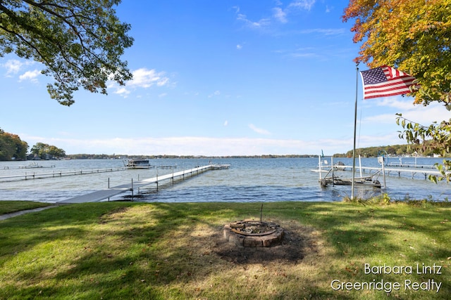 dock area featuring a yard, an outdoor fire pit, and a water view