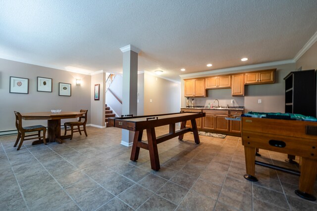 recreation room featuring ornamental molding, a textured ceiling, sink, and tile patterned flooring