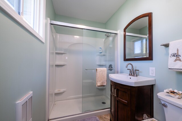 bathroom featuring vanity, toilet, and an enclosed shower