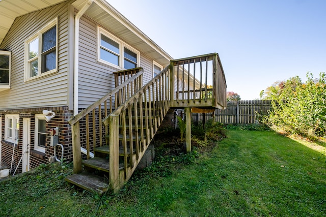 exterior space featuring a wooden deck and a lawn