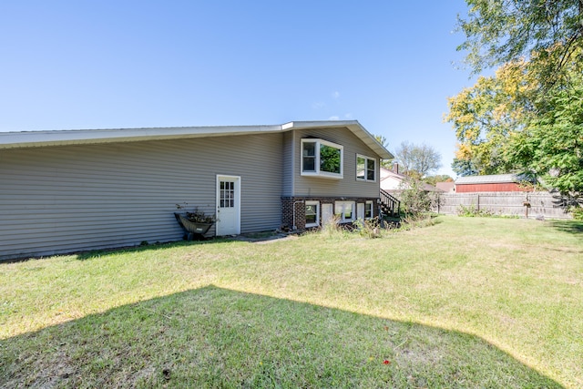 rear view of property with a lawn