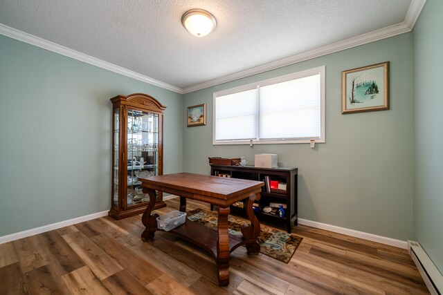 office area featuring a textured ceiling, wood-type flooring, a baseboard radiator, and ornamental molding