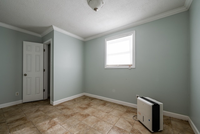 empty room with ornamental molding and a textured ceiling