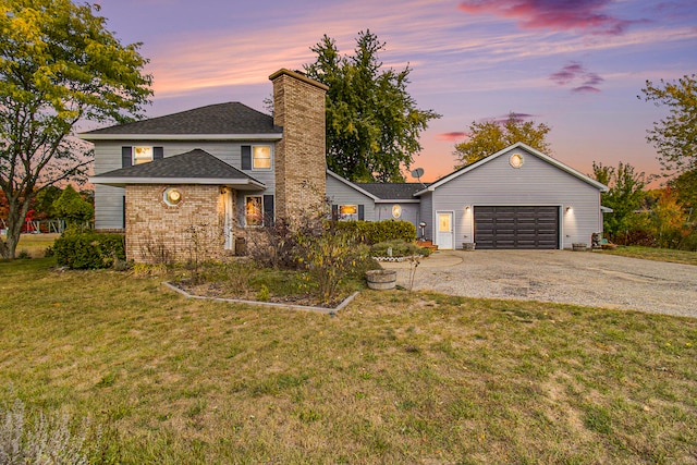 view of front of property with a garage and a lawn