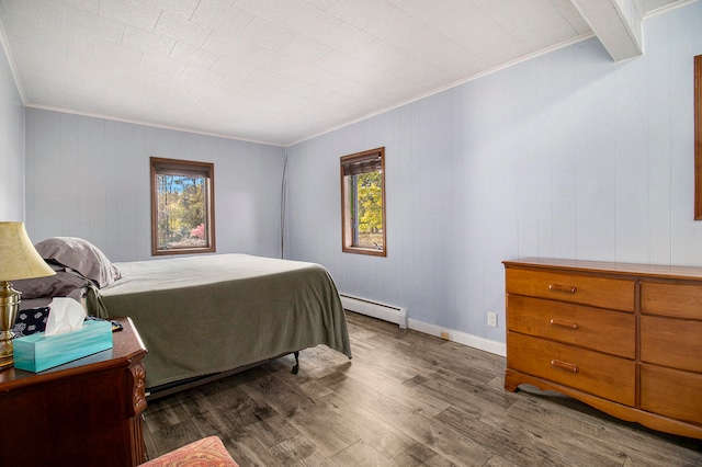 bedroom featuring a baseboard heating unit, dark hardwood / wood-style flooring, ornamental molding, and multiple windows