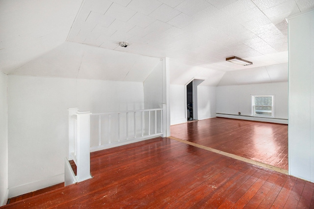 bonus room with baseboard heating, dark wood-type flooring, and lofted ceiling