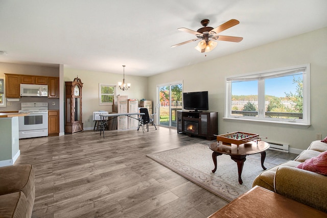 living room featuring a baseboard heating unit, ceiling fan with notable chandelier, and wood-type flooring